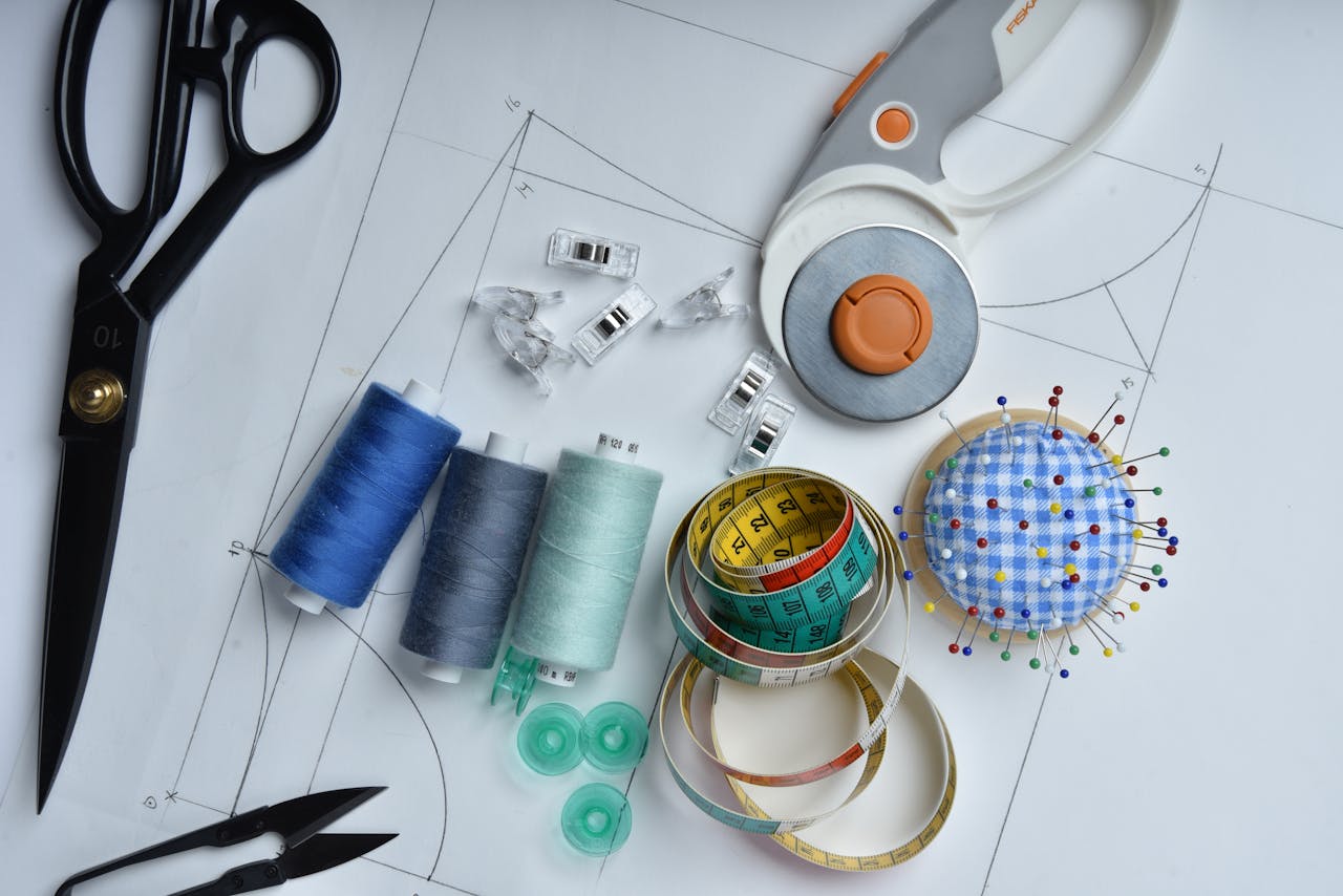 Crafting Captivating Headlines: Your awesome post title goes here A collection of sewing tools including scissors, thread, and rotary cutter on pattern paper, perfect for tailoring.